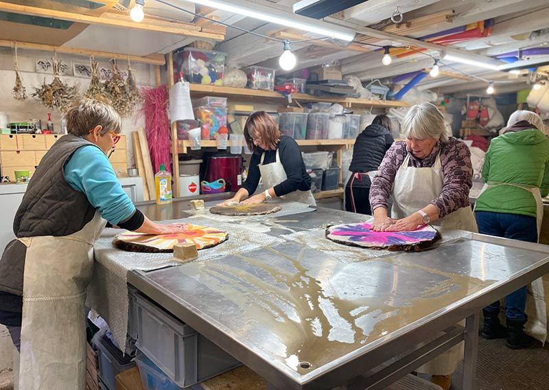 Gutschein – Fellfilzen Workshop: Vier kleine Schafwoll-Sitzfelle filzen. Tagesworkshop von 8-19 Uhr. Inklusive Verpflegung und sämtliches Material. Keine Vorkenntnisse nötig. Du hast in diesem Workshop Zeit um vier kleine runde Schafwollfelle zu filzen. Passend für Stühle. Ein weiches, flauschiges Fell bereichert jede Seele und verströmt die richtige Portion «Gemütlichkeit» in deinem Zuhause. Gefilzte Felle sind Zeugen vom freien Leben der Schafe, sie sind pur, natürlich und aus 100 % Wolle, ganz ohne Leder. Ich bringe dir Schritt für Schritt bei, wie du ein eigenes, handgefertigtes Schaffell herstellst. Dabei werden wir die geschorene, unbehandelte Rohwolle von glücklichen Schafen mit Wasser und Seife so verarbeiten, dass ihre Felloptik möglichst erhalten bleibt. Die Rückseite darfst du individuell gestalten. Fellfilzen ist ein schmutziger aber sinnlicher Job.