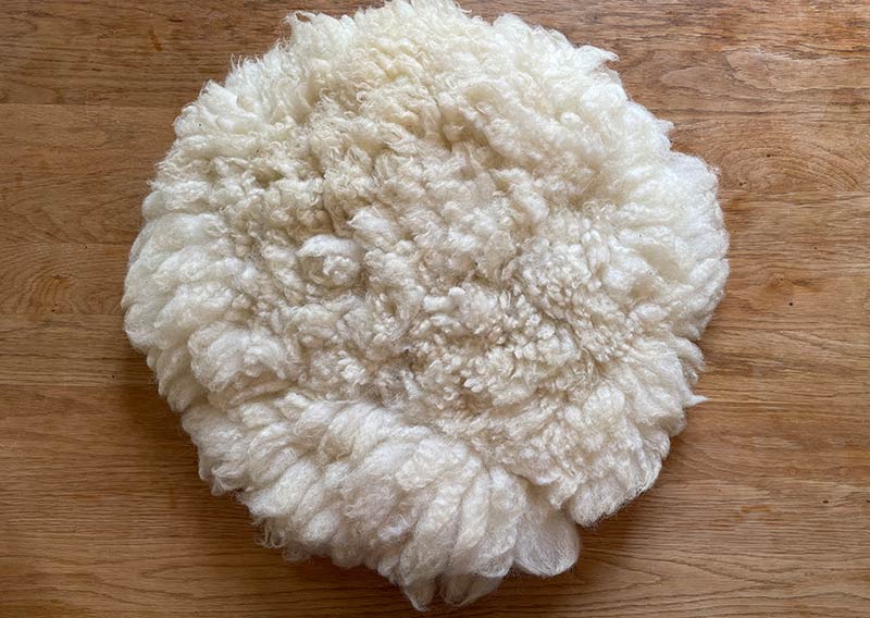 Gutschein – Fellfilzen Workshop: Vier kleine Schafwoll-Sitzfelle filzen. Tagesworkshop von 8-19 Uhr. Inklusive Verpflegung und sämtliches Material. Keine Vorkenntnisse nötig. Du hast in diesem Workshop Zeit um vier kleine runde Schafwollfelle zu filzen. Passend für Stühle. Ein weiches, flauschiges Fell bereichert jede Seele und verströmt die richtige Portion «Gemütlichkeit» in deinem Zuhause. Gefilzte Felle sind Zeugen vom freien Leben der Schafe, sie sind pur, natürlich und aus 100 % Wolle, ganz ohne Leder. Ich bringe dir Schritt für Schritt bei, wie du ein eigenes, handgefertigtes Schaffell herstellst. Dabei werden wir die geschorene, unbehandelte Rohwolle von glücklichen Schafen mit Wasser und Seife so verarbeiten, dass ihre Felloptik möglichst erhalten bleibt. Die Rückseite darfst du individuell gestalten. Fellfilzen ist ein schmutziger aber sinnlicher Job.