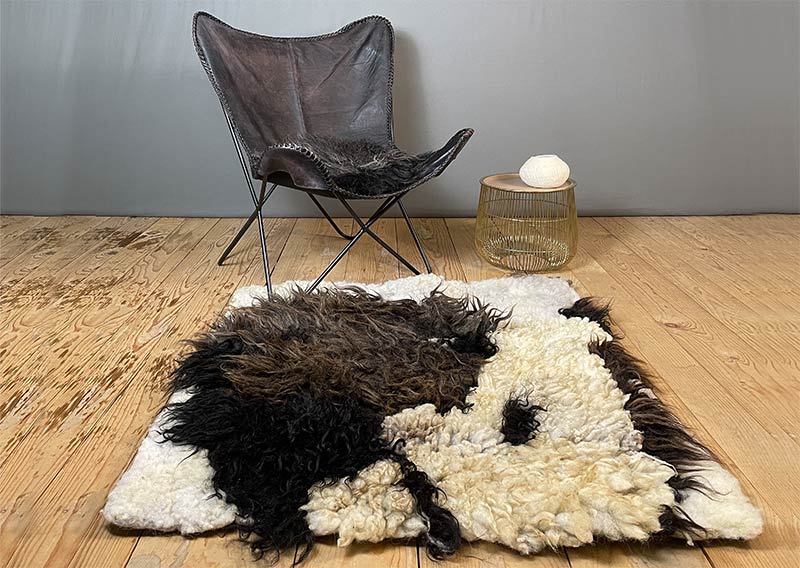 Filzfell aus drei Schafrassen – Ein kunstvolles Unikat.
Dieses aussergewöhnliche Filzfell vereint die Wolle von drei verschiedenen Schafrassen zu einem harmonischen Kunstwerk. Die dunklen, langen Strähnen des Ouessantschafs (ZH) bilden den Mittelpunkt, umrahmt vom tiefschwarzen, leicht gelockten Walliser Landschaf (VS) und dem knuffig-weichen, elfenbeinfarbenen Spiegelschaf (GR). Die Mischung aus Farben und Strukturen macht dieses Stück einzigartig.

Ob als Fellteppich im Wohnbereich, gemütliche Sofadecke oder wärmende Spiel- und Leseoase auf kalten Böden – dieses handgefertigte Unikat bringt Wärme und Charakter in dein Zuhause. Die graue Filzrückseite sorgt für Stabilität und Robustheit, während eine liebevoll gestaltete Eule darauf das Design abrundet.

Ein kunstvolles Naturstück, das nicht nur gemütlich, sondern auch ein echter Blickfang ist.