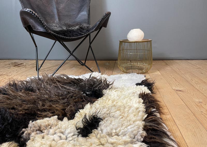 Filzfell aus drei Schafrassen – Ein kunstvolles Unikat.
Dieses aussergewöhnliche Filzfell vereint die Wolle von drei verschiedenen Schafrassen zu einem harmonischen Kunstwerk. Die dunklen, langen Strähnen des Ouessantschafs (ZH) bilden den Mittelpunkt, umrahmt vom tiefschwarzen, leicht gelockten Walliser Landschaf (VS) und dem knuffig-weichen, elfenbeinfarbenen Spiegelschaf (GR). Die Mischung aus Farben und Strukturen macht dieses Stück einzigartig.

Ob als Fellteppich im Wohnbereich, gemütliche Sofadecke oder wärmende Spiel- und Leseoase auf kalten Böden – dieses handgefertigte Unikat bringt Wärme und Charakter in dein Zuhause. Die graue Filzrückseite sorgt für Stabilität und Robustheit, während eine liebevoll gestaltete Eule darauf das Design abrundet.

Ein kunstvolles Naturstück, das nicht nur gemütlich, sondern auch ein echter Blickfang ist.