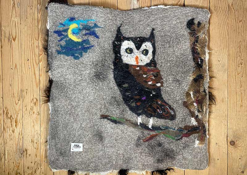 Filzfell aus drei Schafrassen – Ein kunstvolles Unikat.
Dieses aussergewöhnliche Filzfell vereint die Wolle von drei verschiedenen Schafrassen zu einem harmonischen Kunstwerk. Die dunklen, langen Strähnen des Ouessantschafs (ZH) bilden den Mittelpunkt, umrahmt vom tiefschwarzen, leicht gelockten Walliser Landschaf (VS) und dem knuffig-weichen, elfenbeinfarbenen Spiegelschaf (GR). Die Mischung aus Farben und Strukturen macht dieses Stück einzigartig.

Ob als Fellteppich im Wohnbereich, gemütliche Sofadecke oder wärmende Spiel- und Leseoase auf kalten Böden – dieses handgefertigte Unikat bringt Wärme und Charakter in dein Zuhause. Die graue Filzrückseite sorgt für Stabilität und Robustheit, während eine liebevoll gestaltete Eule darauf das Design abrundet.

Ein kunstvolles Naturstück, das nicht nur gemütlich, sondern auch ein echter Blickfang ist.