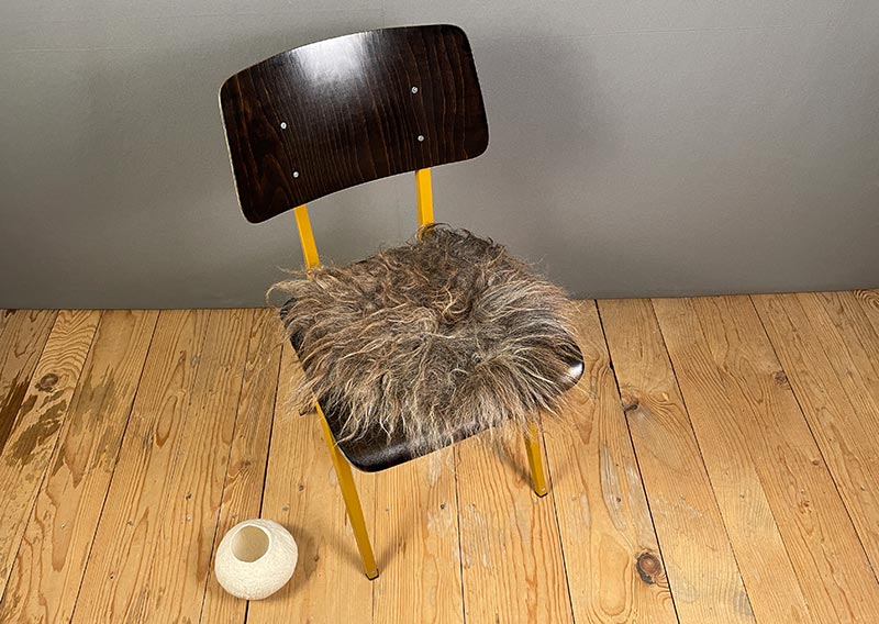 Sitzfell vom Walliser Landschaf – Schokoladenmelange mit Sonnenkuss.
Dieses Sitzfell trägt das Abenteuer schon im Fell. Langsträhnig, ungebändigt, eigenwillig schön – so, wie es eben ein Walliser Landschaf zustande bringt.

Die Farbe erinnert an Schokoladenmelange mit einem Hauch von Sonne, dort, wo die Strähnen leicht sonnengebleicht wirken. Mal schimmert es dunkelbraun, mal anthrazit – als hätte der Wind selbst den Pinsel geführt.

Das Fell ist leicht und beweglich, lässt sich wunderbar zusammenrollen und mitnehmen – sei es auf eine Wanderung, ans Seeufer oder einfach auf den Lieblingsstuhl daheim.

Kein Stück für Perfektionistinnen – aber ein echtes Stück Freiheit.