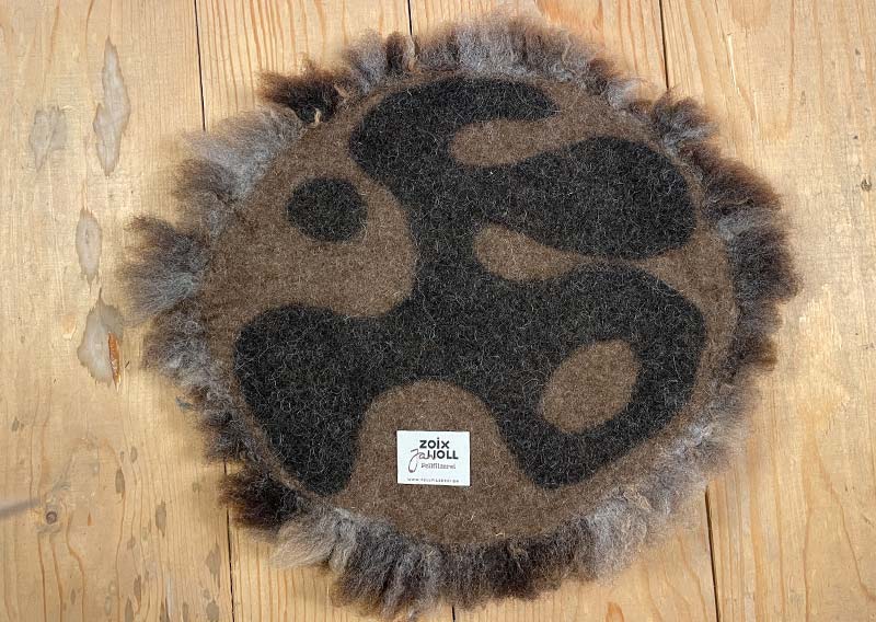 Sitzfell vom Texelschaf – Schokoladenmelange modern.
Dieses Sitzfell stammt von einem blauen Texelschaf von der Insel Texel – ein kompaktes, knuffiges Stück Natur in Schokoladenbraun mit hellen Einsprengseln, ein bisschen wie Schokolade mit einem Hauch Milch. Ein kühles, modernes Braun, das sich mühelos in jede Umgebung einfügt.

Die Wolle ist kräftig, dicht und komfortabel, ideal, um sich darauf niederzulassen, die Seele baumeln zu lassen und einfach den Moment zu geniessen.

Das Texelschaf stammt aus den Niederlanden von der Insel Texel und ist bekannt für seine Vielseitigkeit, Robustheit und sanfte Art. Es liefert Wolle, Fleisch und Ruhepol zugleich – ein echtes Allround-Talent unter den Schafen.

Ein Sitzfell mit Charakter – charmant, ehrlich und jawoll, genau so wie ein Texelschaf es liebt.