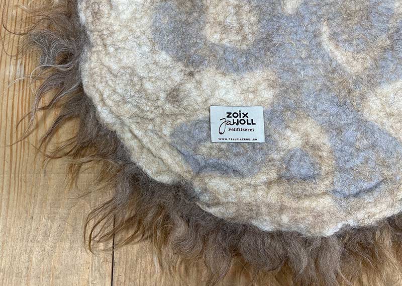 Haselnuss-Honig – Sitzkissen vom Walliser Landschaf.
Manchmal braucht es einfach ein bisschen mehr – mehr Flausch, mehr Wärme, mehr Raum zum Durchatmen. Dieses Sitzfell in Haselnuss-Honig hat Fasern, die bis zu 15 cm lang tanzen dürfen – robust, lebendig und mit einer Prise Wildheit.

Gefilzt aus der Wolle des Walliser Landschafs, einer alten Schweizer Rasse, die von ProSpecieRara erhalten und gefördert wird. Diese genügsamen, wetterfesten Schafe grasen auf den Bergweiden und Alpen – ihr Fell erzählt Geschichten von Wind, Sonne und Fels.

Das Sitzkissen ist etwas grösser im Durchmesser, perfekt für Sessel oder Stühle mit grosszügigerer Sitzfläche.
Ein Stück Bergnatur – zum Draufsitzen, Durchatmen und die Seele im Haselnusslicht baumeln lassen.