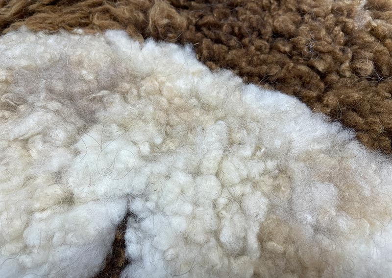 Zwei Schafe. Eine Herde. Ein kleines Wunder aus Graubünden.
Dieses runde, knuffige Sitzfell vereint die warme, braune Wolle eines Bergschafes mit der hellen, sanften Faser eines Spiegelschafes. Gemeinsam erzählen sie ihre Geschichte – von frischer Bündner Bergluft, von Weite, von Zusammenhalt.
Das gefleckte Spiel aus Hell und Braun wirkt wie von der Natur selbst gemalt. Und so fühlt es sich auch an: weich, einladend, herrlich komfortabel. Ein Platz zum Niederlassen. Zum Ankommen. Zum Bleiben.
Ein echtes Stück Herde – für dein Zuhause. Jawoll.