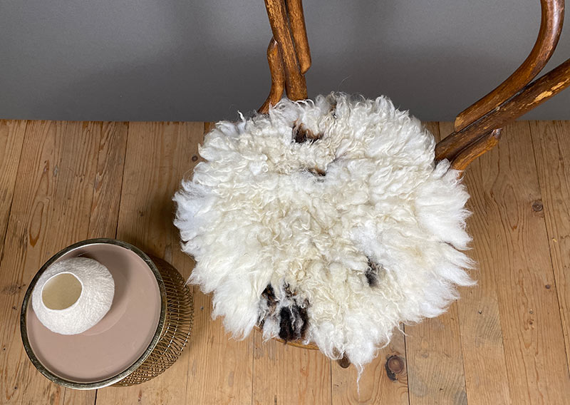 Ein Jakobschaf aus dem Oberemmental – und was für eines.
Das Jakobschaf ist eine alte, ursprüngliche Rasse, bekannt für ihr lebendiges Fleckenmuster und oft sogar für mehrere Hörner. Jedes Tier trägt seine Zeichnung wie ein Unikat – keine zwei Felle sind gleich. Dieses hier zeigt viel leuchtendes Weiss, sanft durchzogen von wenigen schwarzen Tupfern. Wie Schneefelder mit kleinen Schatteninseln.
Rund, weich und wunderbar fluffig schmiegt sich dieses Sitzfell unter dich. Es ist leicht, knuffig und zugleich voller Charakter – ein stiller Blickfang, der Wärme ausstrahlt, ohne laut zu sein.
Ein Stück Oberemmental. Ein bisschen Ursprünglichkeit. Und ganz viel Behaglichkeit. Jawoll.